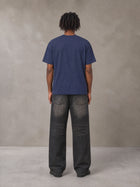 Model wearing the SM Emblem T-shirt in Oxford Navy, rear view.