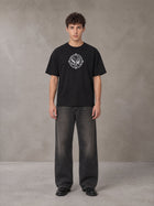 Model wearing the SM Emblem T-shirt in Midnight Black, front view.