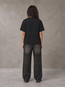 Model wearing the SM Emblem T-shirt in Midnight Black, rear view.