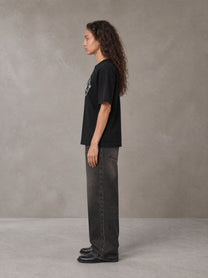 Model wearing the SM Emblem T-shirt in Midnight Black, side profile.