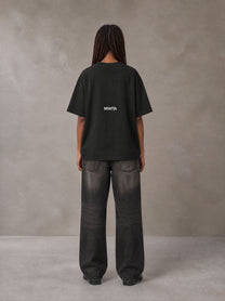 Model wearing the SM Fleur Matrix T-shirt in Midnight Black, rear view.