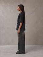 Model wearing the SM Fleur Matrix T-shirt in Midnight Black, side profile.