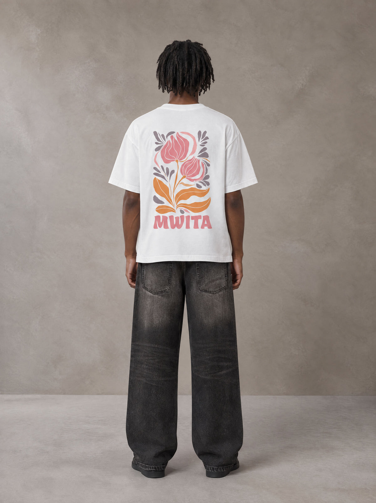 Model wearing the SM Floral Essence T-shirt in Lucent White, rear view.