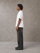 Model wearing the SM Floral Essence T-shirt in Lucent White, side profile.