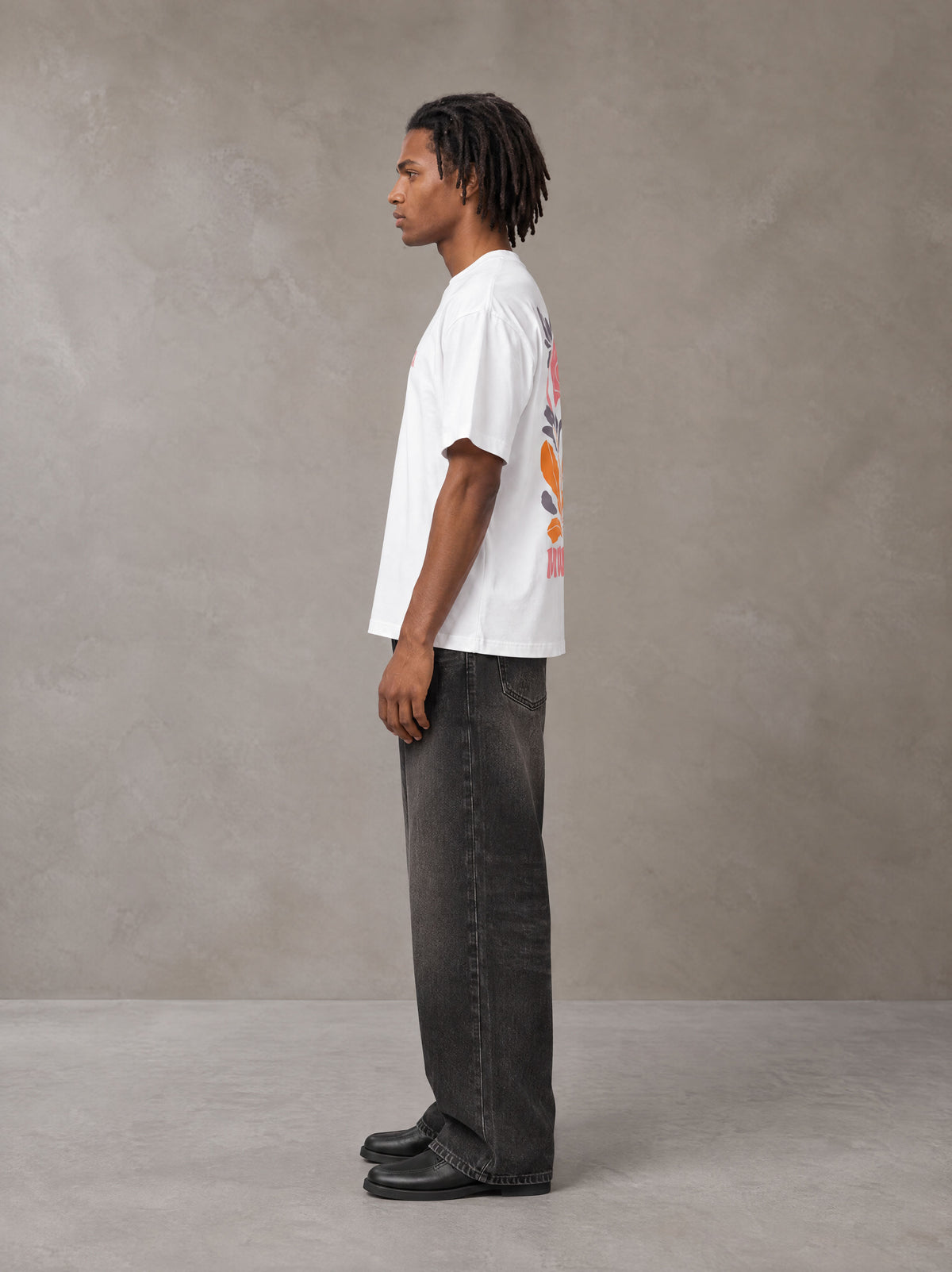 Model wearing the SM Floral Essence T-shirt in Lucent White, side profile.