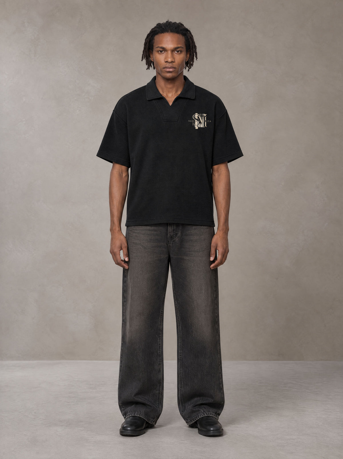 Model wearing the SM Glyph Polo T-shirt in Midnight Black, front view.