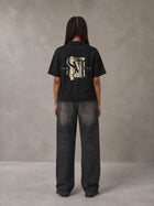 Model wearing the SM Glyph Polo T-shirt in Midnight Black, rear view.