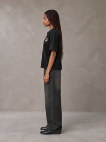 Model wearing the SM Glyph Polo T-shirt in Midnight Black, side profile.