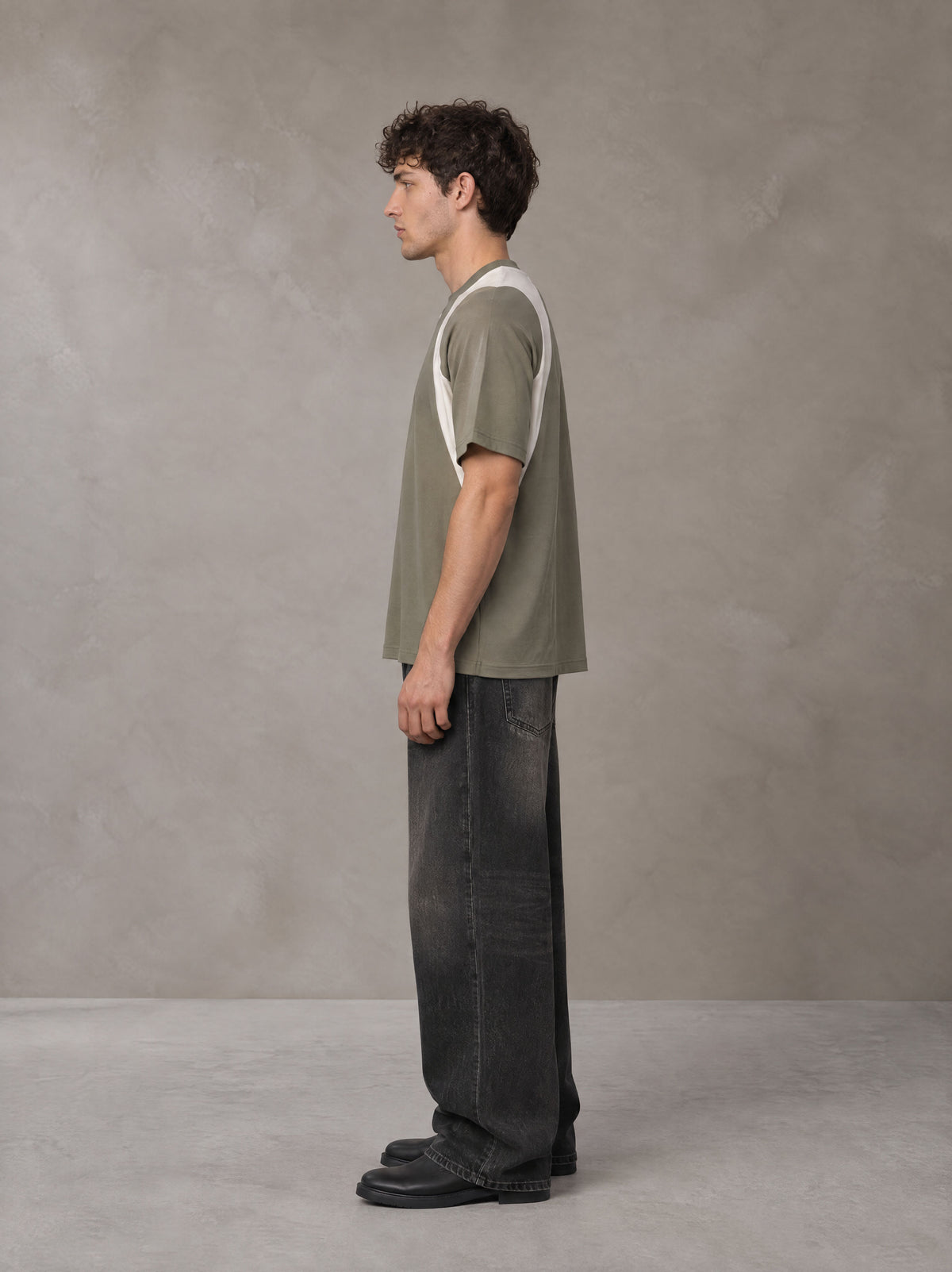 Model wearing the SM Graffiti Stack T-shirt in Coffee Grey, side profile.
