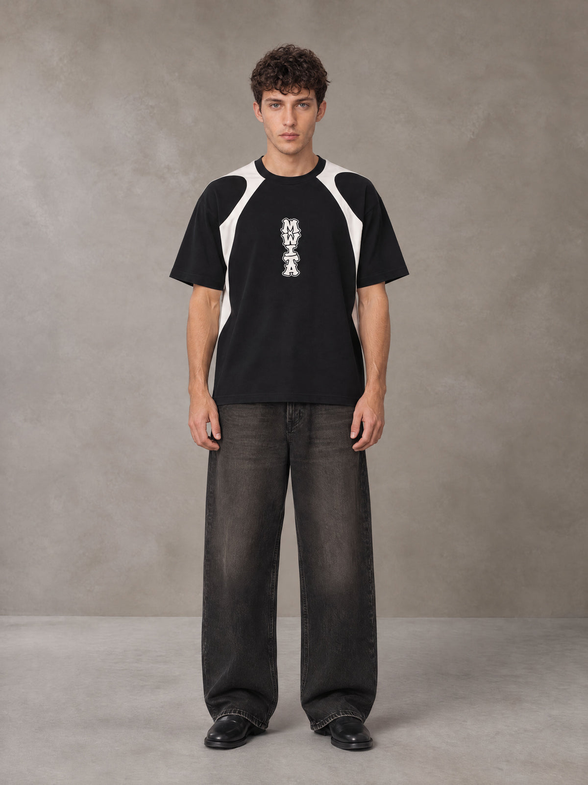 Model wearing the SM Graffiti Stack T-shirt in Midnight Black, front view.
