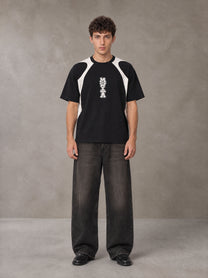 Model wearing the SM Graffiti Stack T-shirt in Midnight Black, front view.