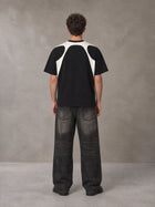 Model wearing the SM Graffiti Stack T-shirt in Midnight Black, rear view.