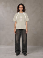 Model wearing the SM Graffiti Stack T-shirt in Oatmeal Cookie, front view.