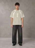 Model wearing the SM Graffiti Stack T-shirt in Oatmeal Cookie, front view.
