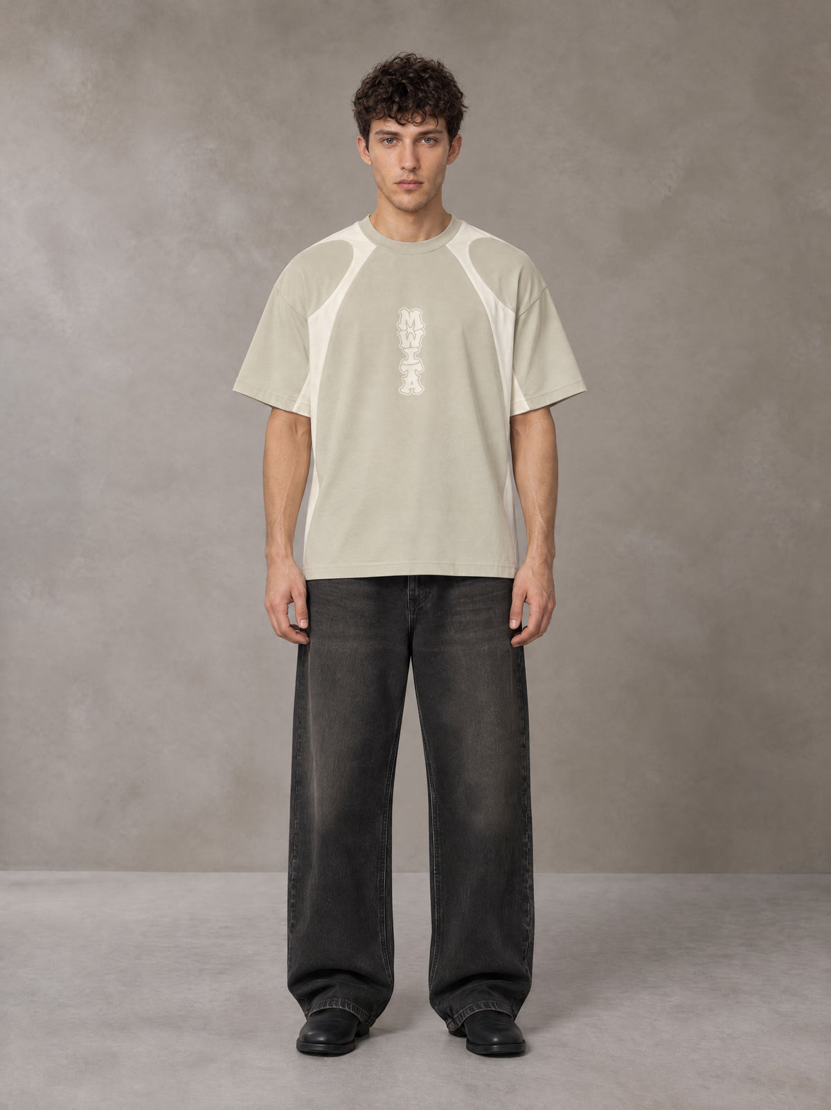 Model wearing the SM Graffiti Stack T-shirt in Oatmeal Cookie, front view.