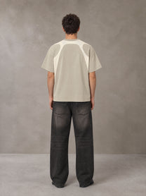 Model wearing the SM Graffiti Stack T-shirt in Oatmeal Cookie, rear view.