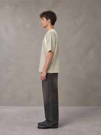 Model wearing the SM Graffiti Stack T-shirt in Oatmeal Cookie, side profile.