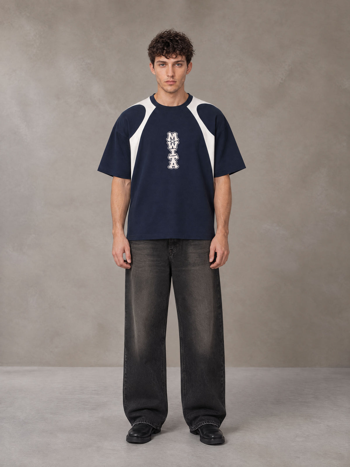 Model wearing the SM Graffiti Stack T-shirt in Oxford Navy, front view.