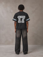 Model wearing the SM Gridiron T-shirt in Midnight Black, rear view.