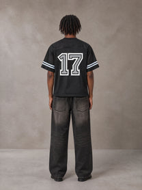 Model wearing the SM Gridiron T-shirt in Midnight Black, rear view.