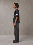 Model wearing the SM Gridiron T-shirt in Midnight Black, side profile.