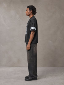Model wearing the SM Gridiron T-shirt in Midnight Black, side profile.