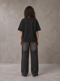 Model wearing the SM Halcyon T-shirt in Midnight Black, rear view.