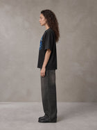 Model wearing the SM Halcyon T-shirt in Midnight Black, side profile.