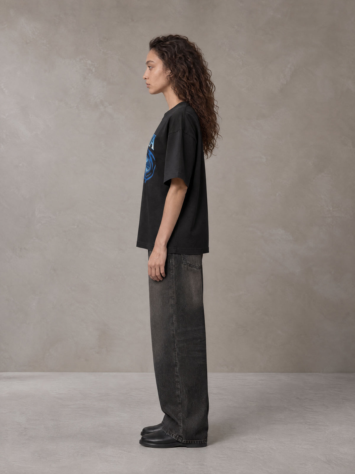 Model wearing the SM Halcyon T-shirt in Midnight Black, side profile.