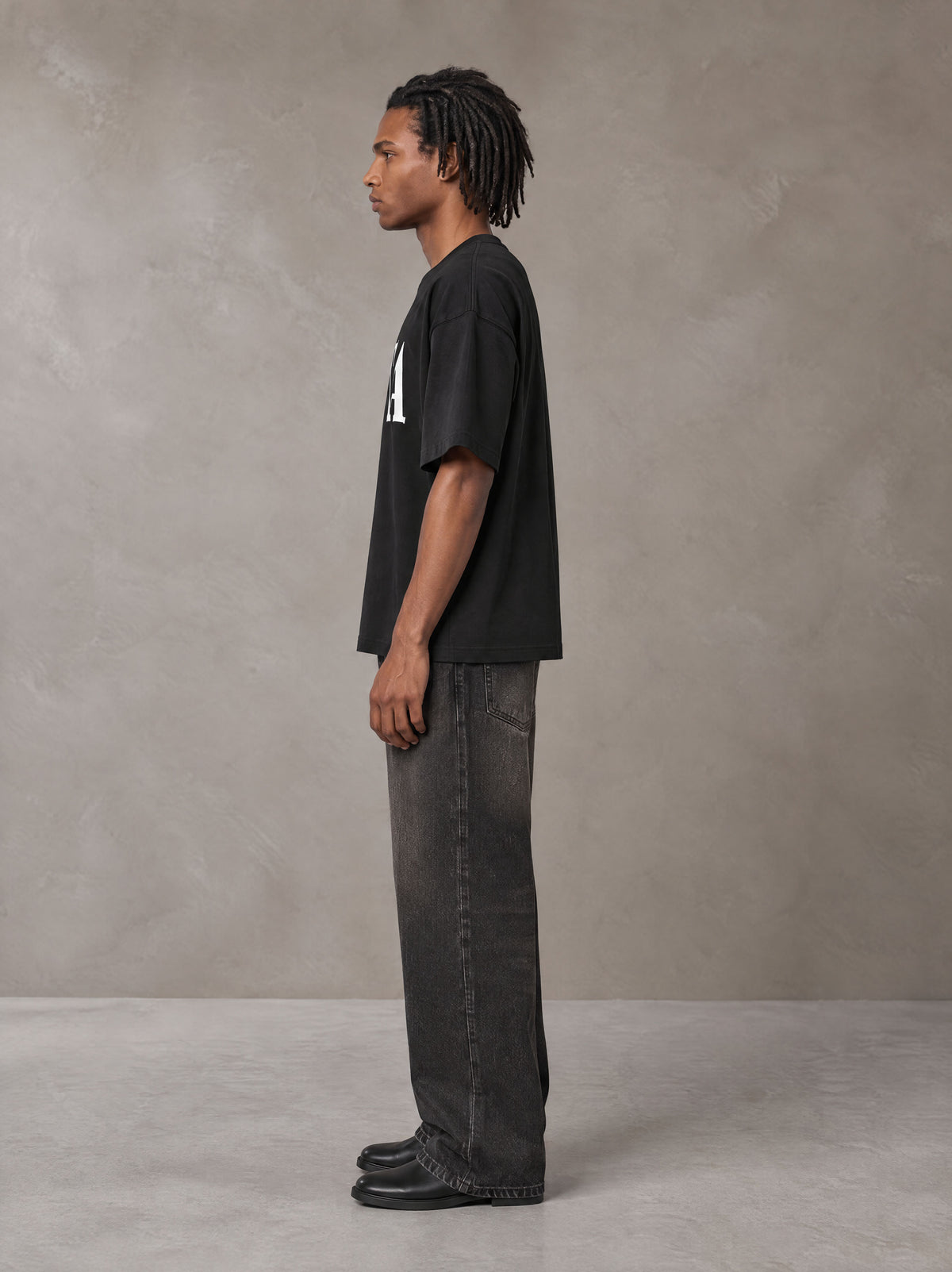 Model wearing the SM Heritage T-shirt in Midnight Black, side profile.
