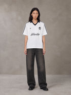 Model wearing the SM Legacy Jersey Polo T-shirt in Lucent White, front view.