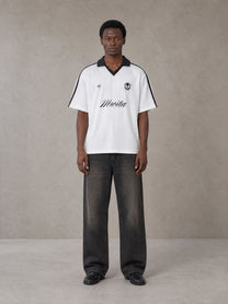 Model wearing the SM Legacy Jersey Polo T-shirt in Lucent White, front view.