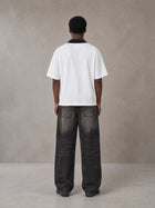 Model wearing the SM Legacy Jersey Polo T-shirt in Lucent White, rear view.