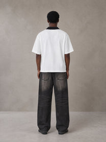 Model wearing the SM Legacy Jersey Polo T-shirt in Lucent White, rear view.
