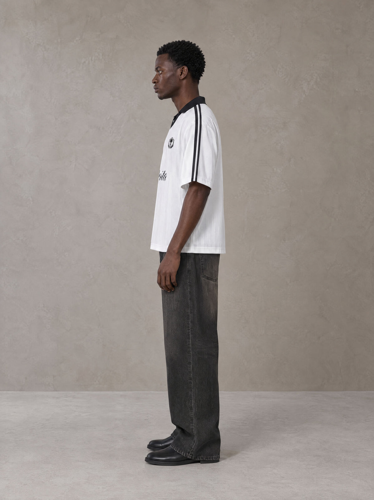 Model wearing the SM Legacy Jersey Polo T-shirt in Lucent White, side profile.