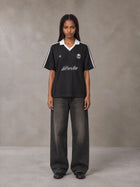Model wearing the SM Legacy Jersey Polo T-shirt in Midnight Black, front view.