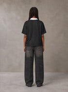 Model wearing the SM Legacy Jersey Polo T-shirt in Midnight Black, rear view.