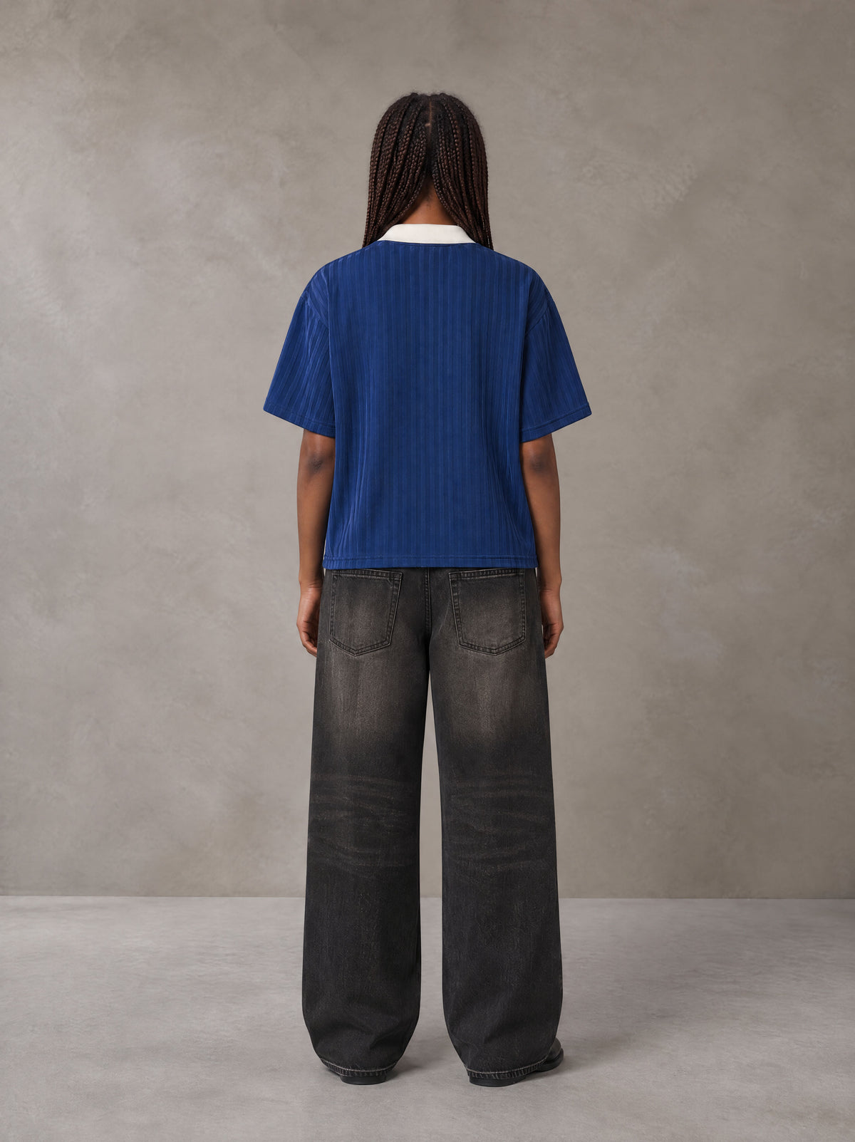 Model wearing the SM Legacy Jersey Polo T-shirt in Oxford Navy, rear view.