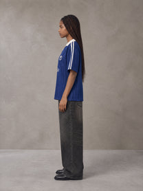 Model wearing the SM Legacy Jersey Polo T-shirt in Oxford Navy, side profile.