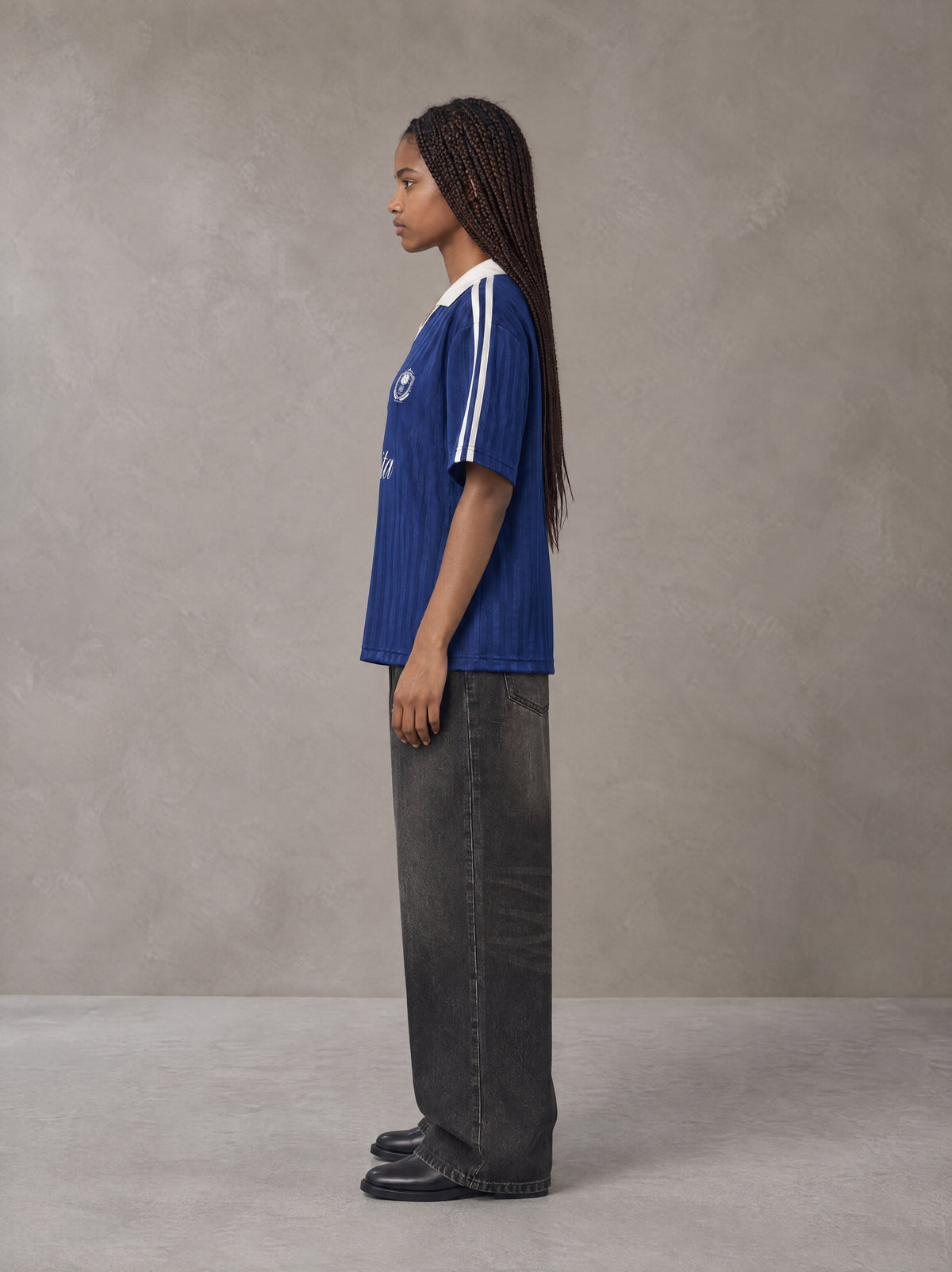 Model wearing the SM Legacy Jersey Polo T-shirt in Oxford Navy, side profile.