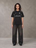Model wearing the SM Legacy Jersey T-shirt in Midnight Black, front view.