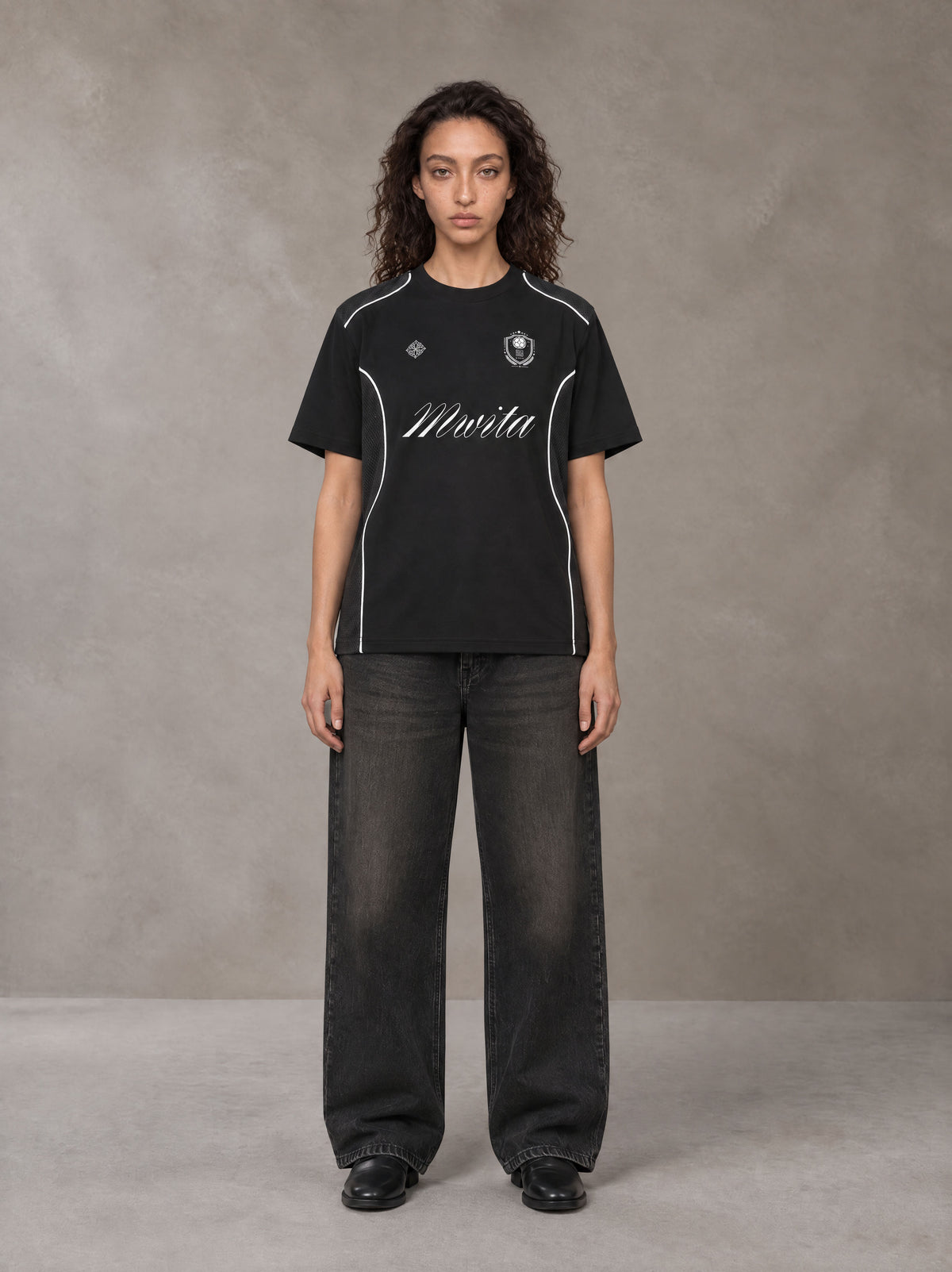 Model wearing the SM Legacy Jersey T-shirt in Midnight Black, front view.