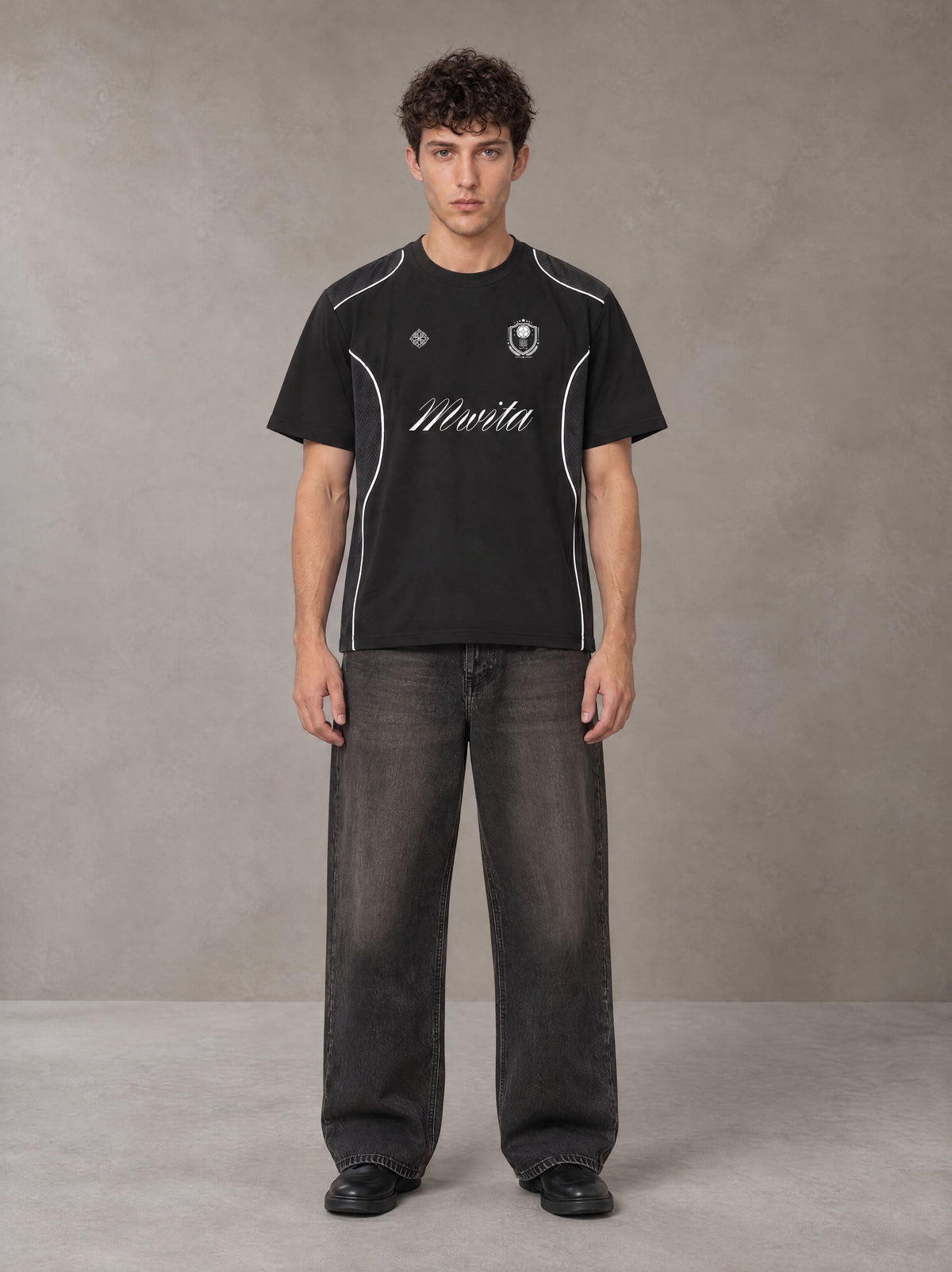 Model wearing the SM Legacy Jersey T-shirt in Midnight Black, front view.