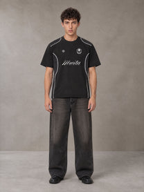 Model wearing the SM Legacy Jersey T-shirt in Midnight Black, front view.
