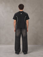 Model wearing the SM Legacy Jersey T-shirt in Midnight Black, rear view.