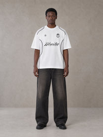 Model wearing the SM Legacy Jersey T-shirt in Lucent White, front view.