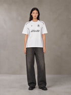 Model wearing the SM Legacy Jersey T-shirt in Lucent White, front view.