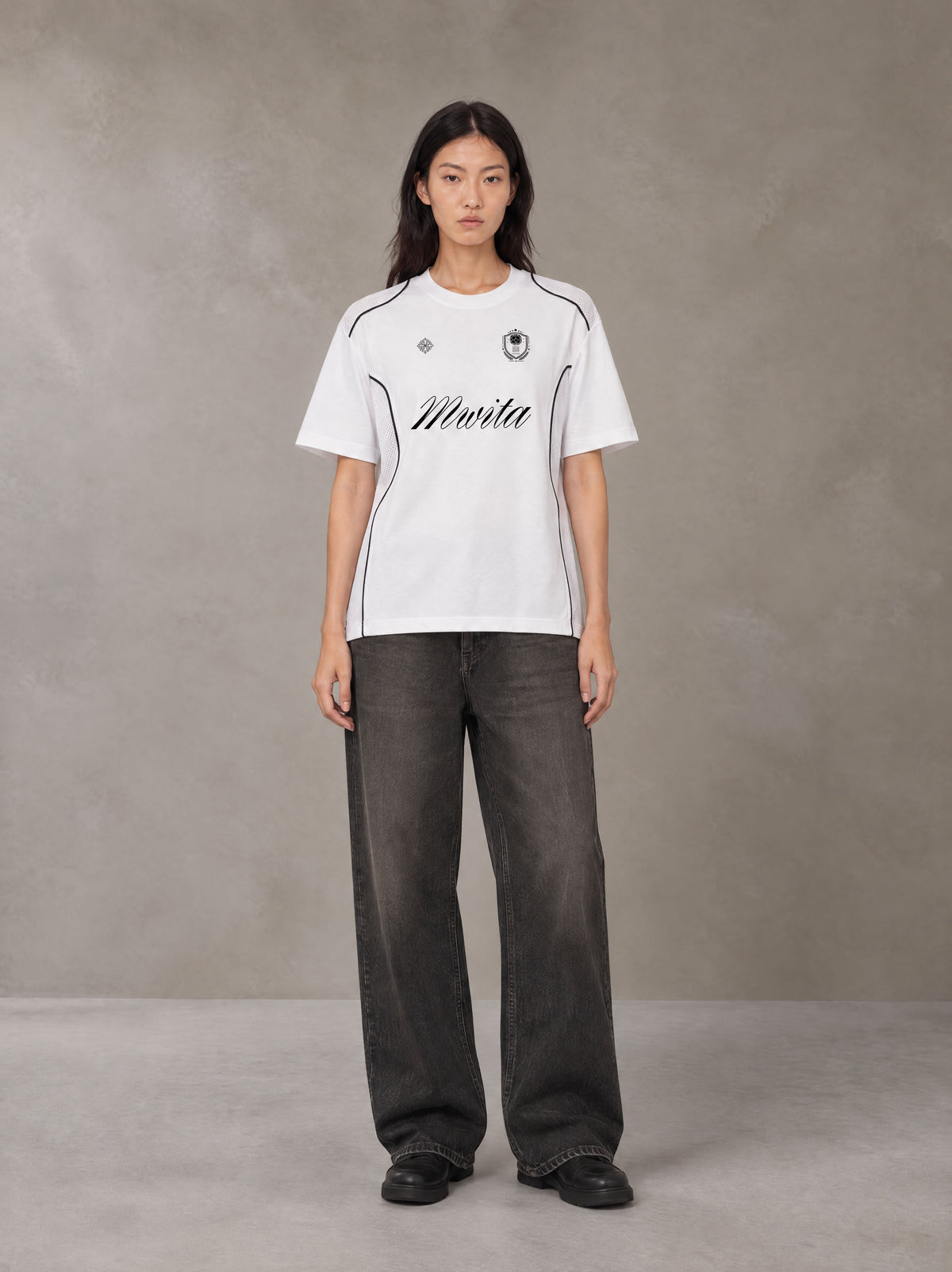 Model wearing the SM Legacy Jersey T-shirt in Lucent White, front view.