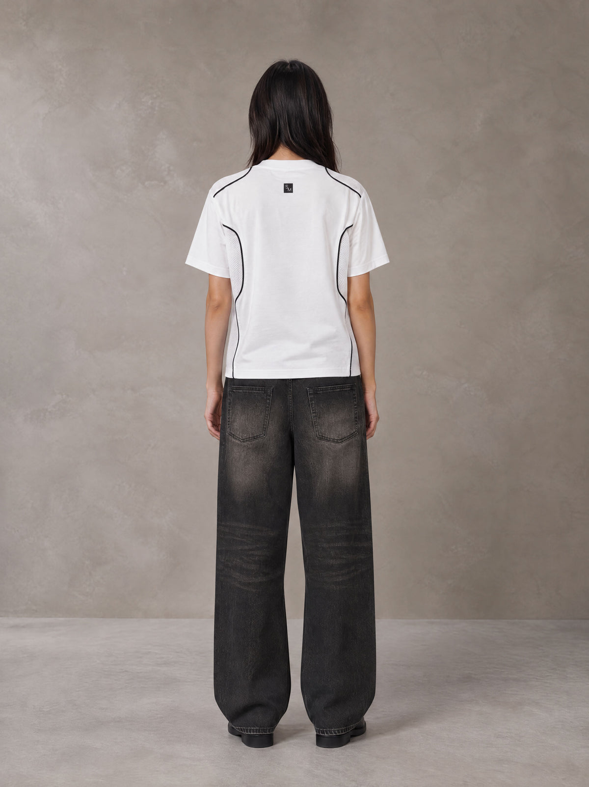 Model wearing the SM Legacy Jersey T-shirt in Lucent White, rear view.