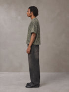 Model wearing the SM Leopard Print Boxy T-shirt in Granite Green, side profile.